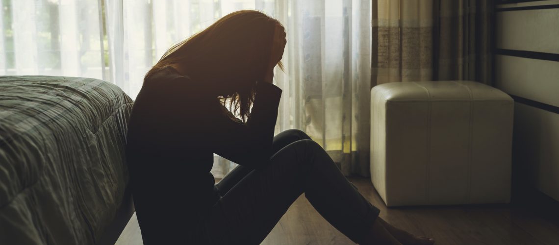 depressed and betrayed woman sitting in the dark bedroom